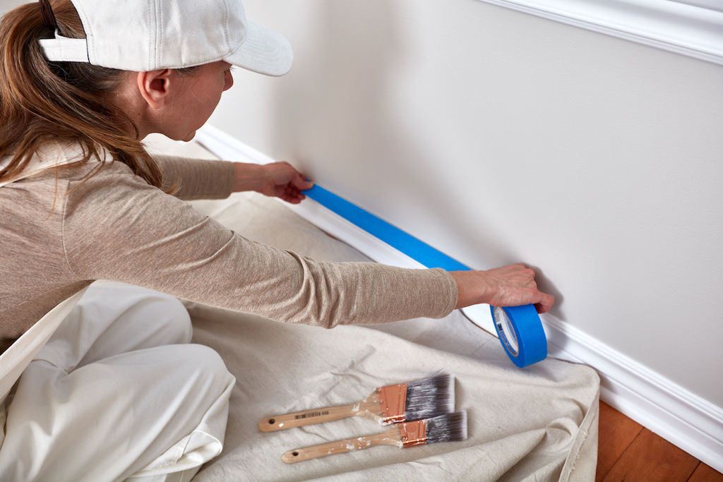 Painter protecting apartment baseboards